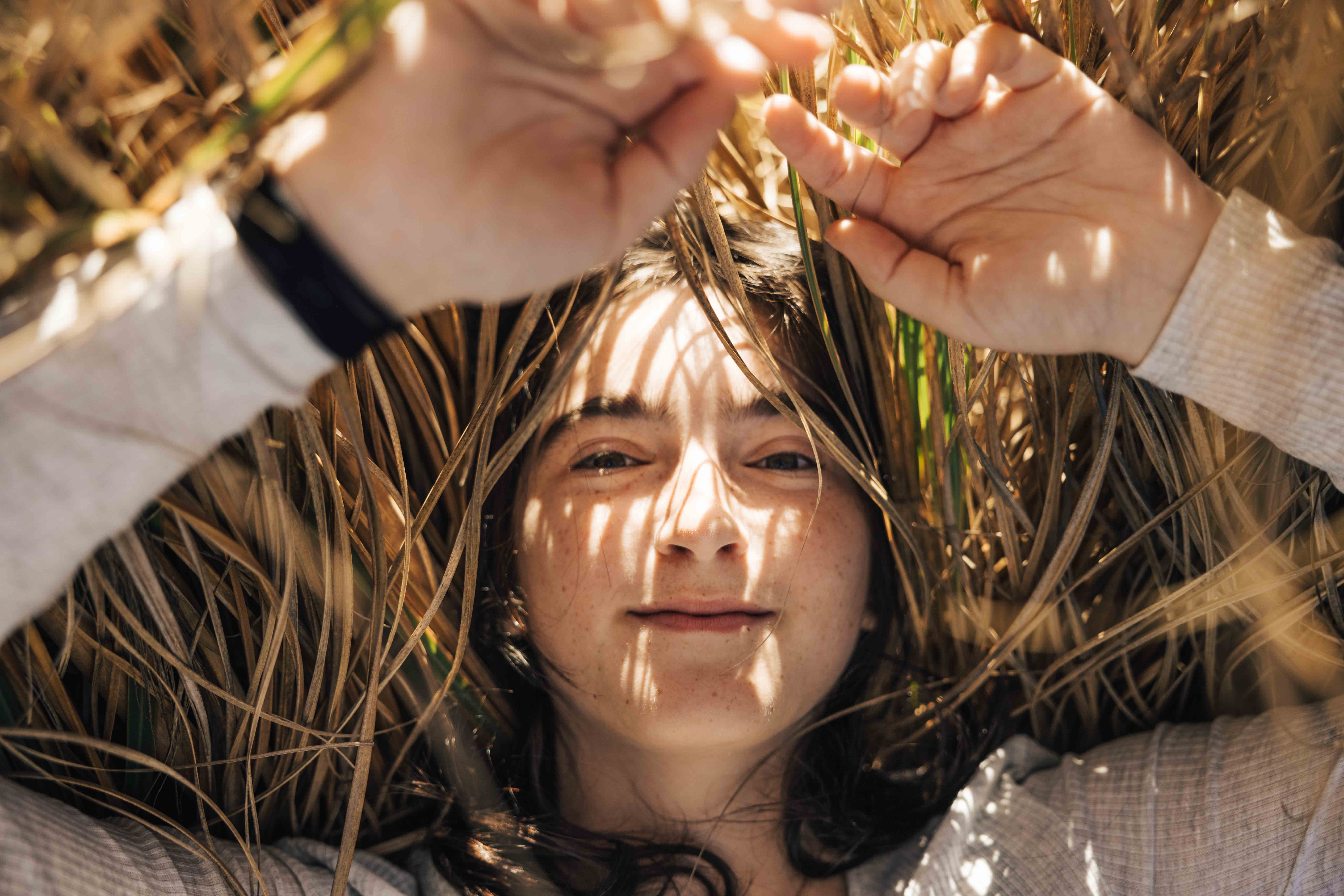 High school senior laying in the tall grass.