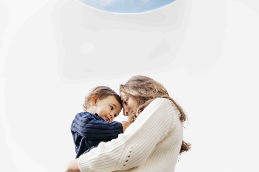 Mother is holding son in her arms in the Turrell skyspace at the DeYoung.