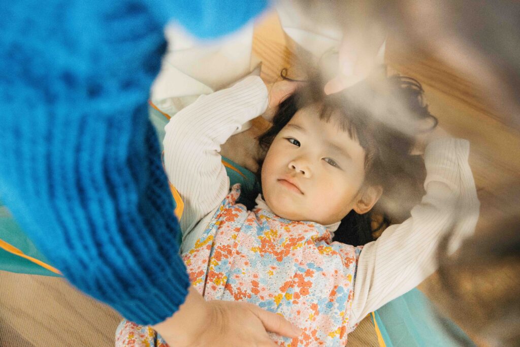 Mom gently combs her fingers through her daughter's hair.