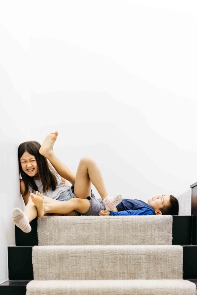 Sibling kids are goofing around with limbs kicking everywhere.