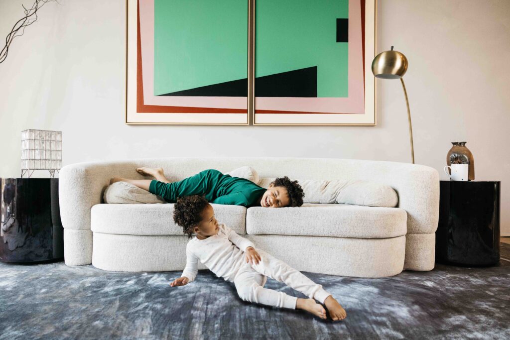 Brother and sister are hanging out together in the living room in their pajamas.