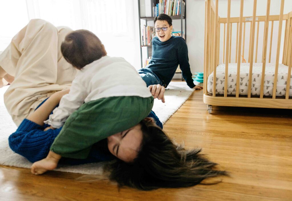 Toddler son is having a fun, raucous time sitting on his mom's head.