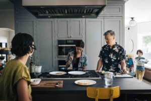 Family is making pancakes during a family photo session at home.