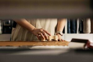 A textile artist is pressing a stamp to block print onto fabric.