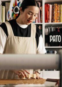 Textile designer is hand blocking onto fabric.