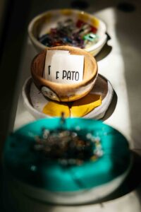 Small ceramic bowls of pins and clips sit in the sun.