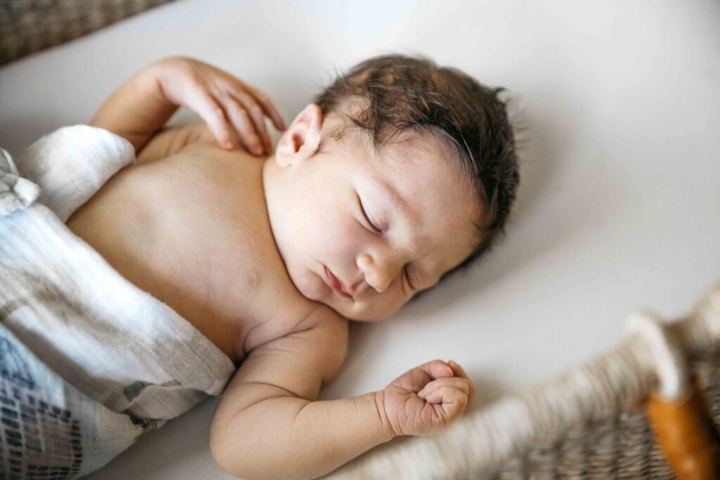 Newborn baby boy sleeps quietly in a rocker.