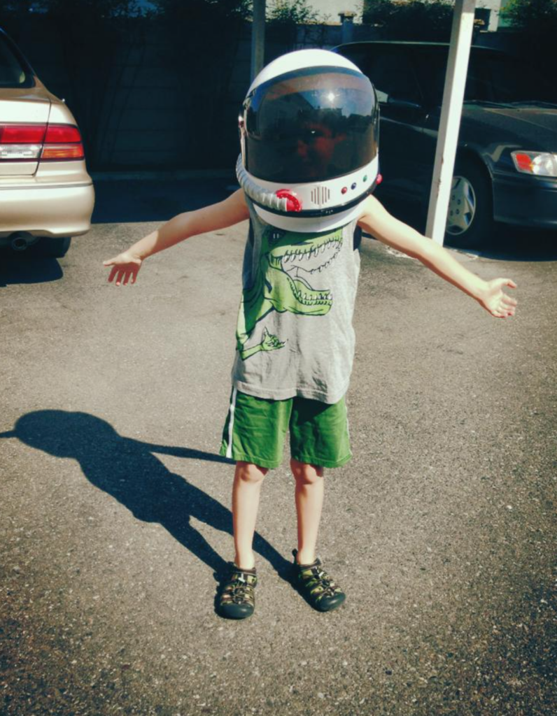 Toddler version of senior graduate wearing his beloved astronaut helmet.