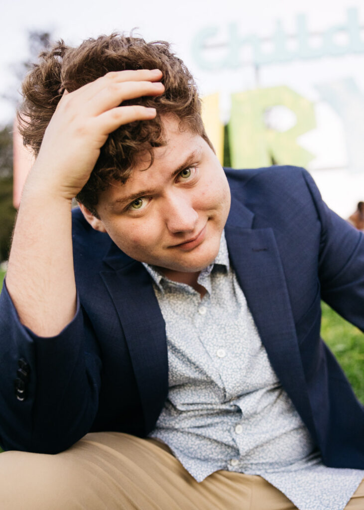 High school grad is running his fingers through his hair during a family photo session.