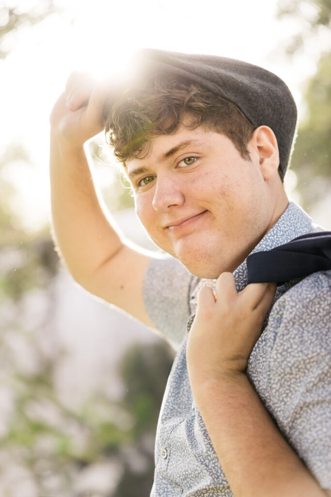 High school graduate is tipping his Kangol hat during his senior photo session with Carmen Dunham.