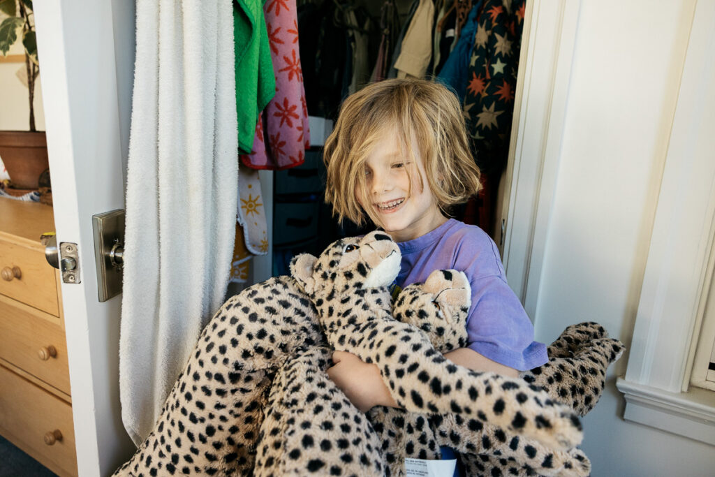 Young boy is fetching five stuffed cheetahs from his bedroom closet.